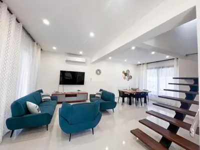 a living room with blue chairs and a table at Villas Montemar - Villa Sol in Las Terrenas