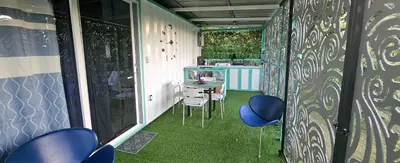 a room with chairs and a table with green flooring at BlueEcolandia Bungalow AGUA in Jarabacoa