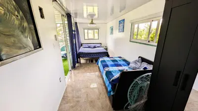 a small room with two beds and a window at BlueEcolandia Bungalow AGUA in Jarabacoa