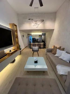 a living room with a couch and a tv at Aqua Loft 120 in La Puntica de Juan Dolio