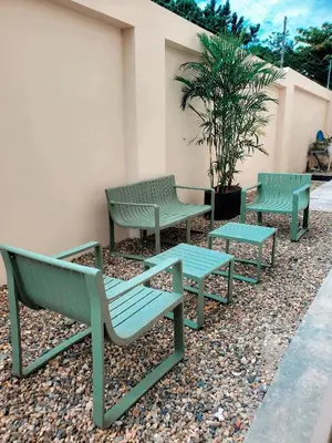 three green benches sitting next to a building at Apartamento moderno 3H en TREO zona metropolitana in Santiago de los Caballeros