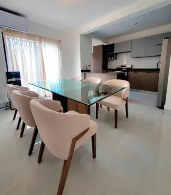 a dining room with a glass table and chairs at Apartamento moderno 3H en TREO zona metropolitana in Santiago de los Caballeros
