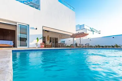 a swimming pool in front of a house at Villa Ruby Bella in Sosúa