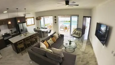 a living room with a couch and a kitchen and a table at Villa Ruby Bella in Sosúa