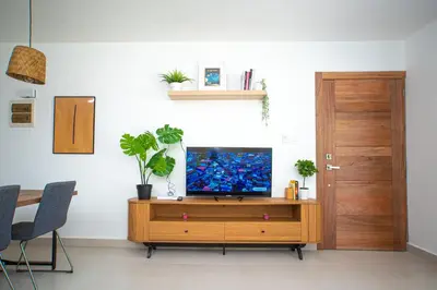 a living room with a television on a wooden cabinet at CMB202 BEACH AREA Res Cristamar in Eslabón