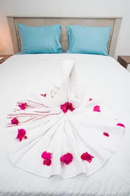 a white dress with pink flowers on a bed at CMB202 BEACH AREA Res Cristamar in Eslabón