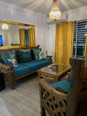 a living room with a blue couch and a table at Cozy Retreat 1st Floor in Arenoso