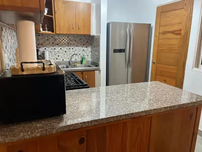 a kitchen with a granite counter top and a refrigerator at Cozy Retreat 1st Floor in Arenoso