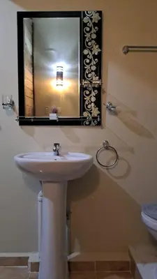 a bathroom with a sink and a mirror and a toilet at Habitación Taina in Jarabacoa