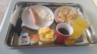 a tray of food with breakfast foods and a glass of orange juice at Habitación Taina in Jarabacoa