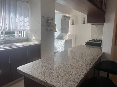 a kitchen with a counter top and a refrigerator at Santuario Tropical at Marino Paradise in La Puntica de Juan Dolio