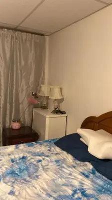 a bedroom with a bed and a table with a lamp at Rancho silvestre in Monte Plata