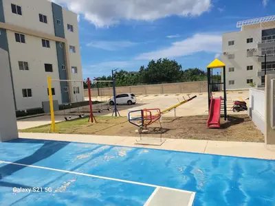 a playground in a parking lot with a playground at Romana Tropical in La Romana