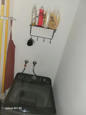 a washing machine in a room with a shelf at Romana Tropical in La Romana