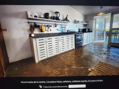 a kitchen with white cabinets and a counter top at Villa Los Corralillos in Cabrera