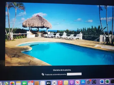 a television screen showing a swimming pool with chairs and a umbrella at Villa Los Corralillos in Cabrera