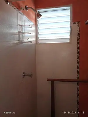 a bathroom with a shower and a window at Atabeba in Las Galeras