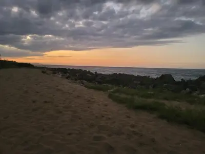 a beach at sunset with the ocean in the background at Blue fish apartamento in Sosúa