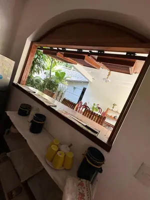 a window in a room with yellow mugs on a shelf at Casa Mariana in Las Terrenas