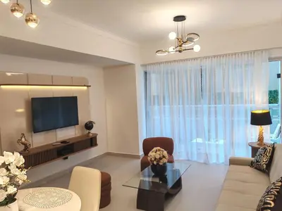 a living room with a tv and a couch and a table at Style and Confort Apart Villa Palmera in Santo Domingo