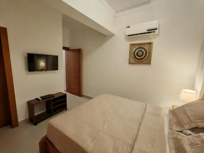 a hotel room with a bed and a television at Style and Confort Apart Villa Palmera in Santo Domingo