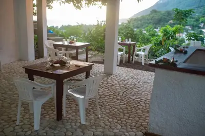 a patio with white chairs and tables with a view at Hotel-Restaurante Snack Cana in La Ciénaga