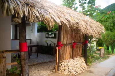 a small hut with a straw roof and a table at Hotel-Restaurante Snack Cana in La Ciénaga