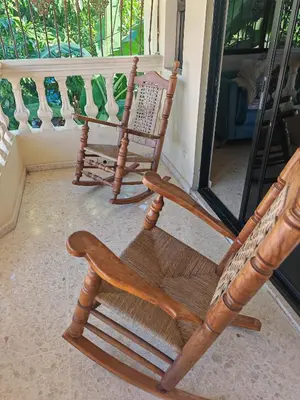 two wooden rocking chairs sitting on a porch at Habitación cuádruple Casa Grande Corales del Sur in La Viva