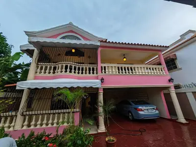 a pink house with a car parked in front at Habitación cuádruple Casa Grande Corales del Sur in La Viva