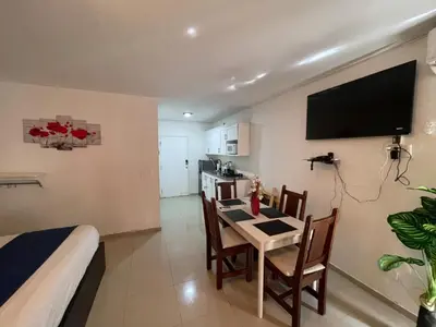 a room with a kitchen and a table with chairs at OCEANPARADISE to you ALBATRO l Y ll in Juan Dolio