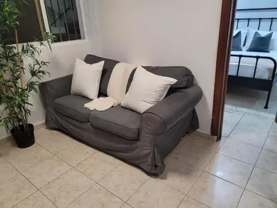 a brown couch with white pillows in a living room at Fantastic with Terrace in the colonial zone in Santo Domingo