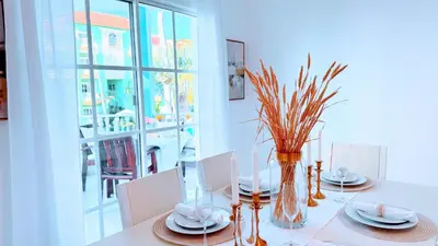 a dining room with a white table and a window at Walk to Beach, Shops, Dining, Pool View, Fast Wifi in Punta Cana