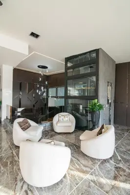 a living room with three white chairs and a table at lovera hotel in Santiago de los Caballeros
