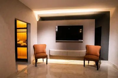 two chairs in a room with a flat screen tv at lovera hotel in Santiago de los Caballeros
