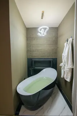 a bathroom with a bath tub and a sink at lovera hotel in Santiago de los Caballeros