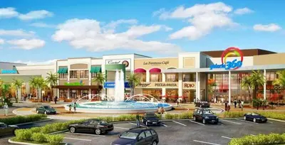 a shopping center with cars parked in a parking lot at Apartamento en Arroyo Hondo viejo in Santo Domingo