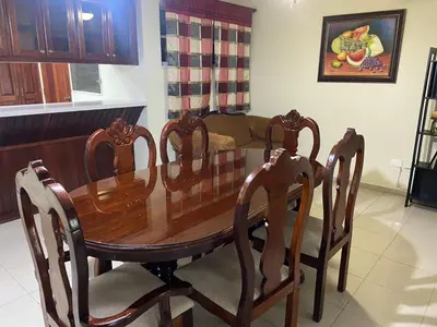 a wooden table and chairs in a living room at Apartamento en Arroyo Hondo viejo in Santo Domingo