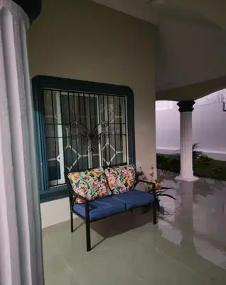 a chair sitting in a room with a window at Encantadora Casa Familiar en Santiago in Santiago de los Caballeros