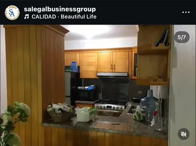 a kitchen with wooden cabinets and a black appliances at S A Business RENTAL SALE in Juan López