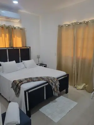 a bedroom with a large bed and curtains at The Omelís House in Santa Bárbara de Samaná