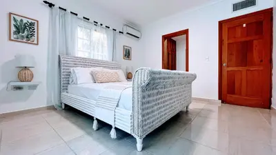 a bedroom with a wicker bed and a window at Pool View, Walk to Beach, Shops, Dining, Fast Wifi in Punta Cana