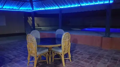 a table and chairs in a room with a pool at Finca im Grünen, sehr ruhige Lage, Terrasse mit Pool in Baní