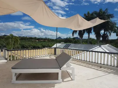 a bed and an umbrella on a patio at Finca im Grünen, sehr ruhige Lage, Terrasse mit Pool in Baní