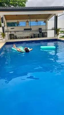 a person laying on a surfboard in a swimming pool at aparthotel las taranas in Villa Riva