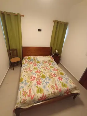 a bedroom with a bed with a floral bedspread at Casa Maritza in Las Galeras