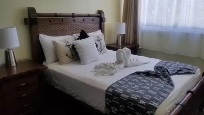 a bedroom with a bed with two stuffed animals on it at My Deligth in San Felipe de Puerto Plata