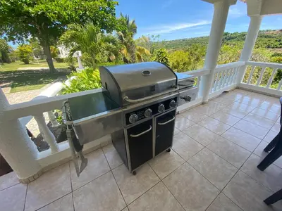 a grill on a balcony with a view of the ocean at Casa Blanca Samaná - Las Galeras in Las Galeras