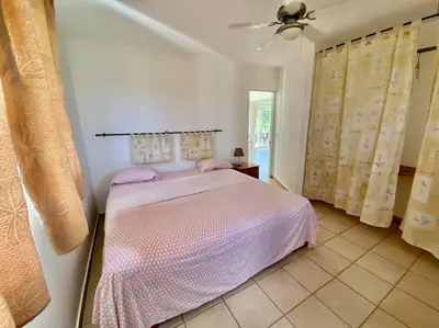 a bedroom with a bed and a ceiling fan at Casa Blanca Samaná - Las Galeras in Las Galeras