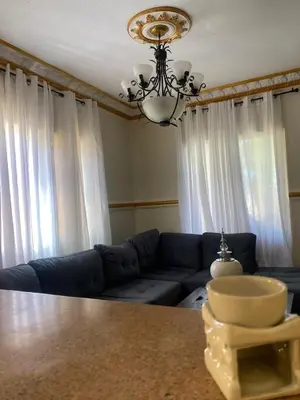 a living room with a blue couch and a chandelier at casa en Puerto Plata para 2 in San Felipe de Puerto Plata