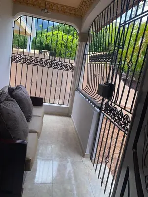 a balcony with a couch and a view of a garden at casa en Puerto Plata para 2 in San Felipe de Puerto Plata
